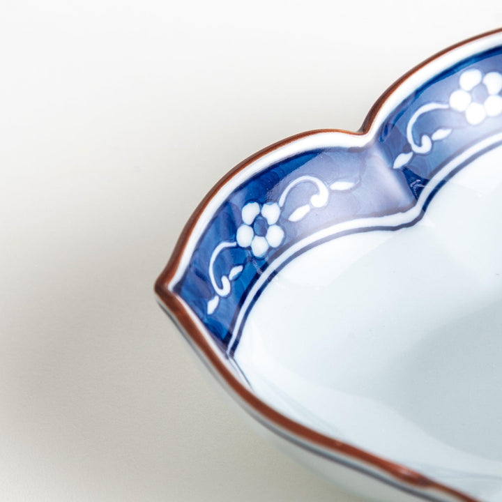 A ceramic bowl with a cloud-like shape and a blue patterned rim.