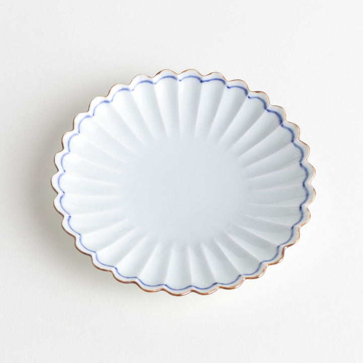 A small round plate with a scalloped edge and a delicate blue rim