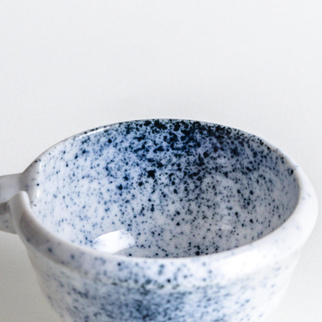 A small condiment bowl with blue speckled patterns on a white background.