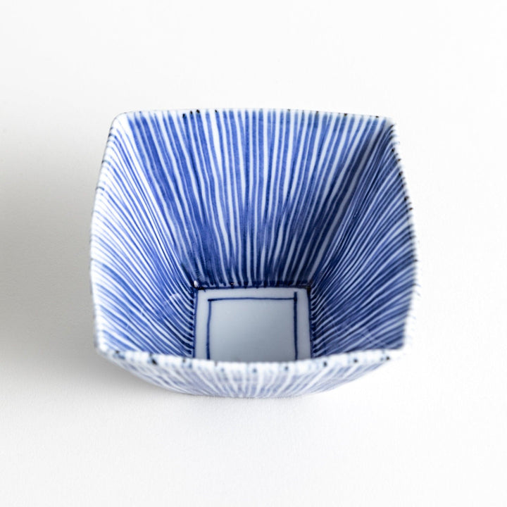 A small, square white plate with a geometric pattern of intersecting blue lines.