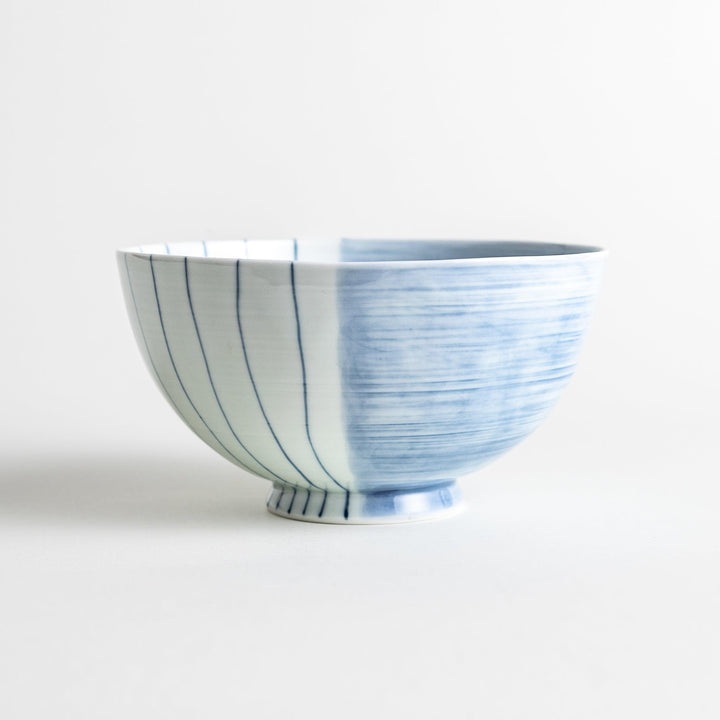 A white ceramic bowl with vertical blue stripes in a simple, clean design.