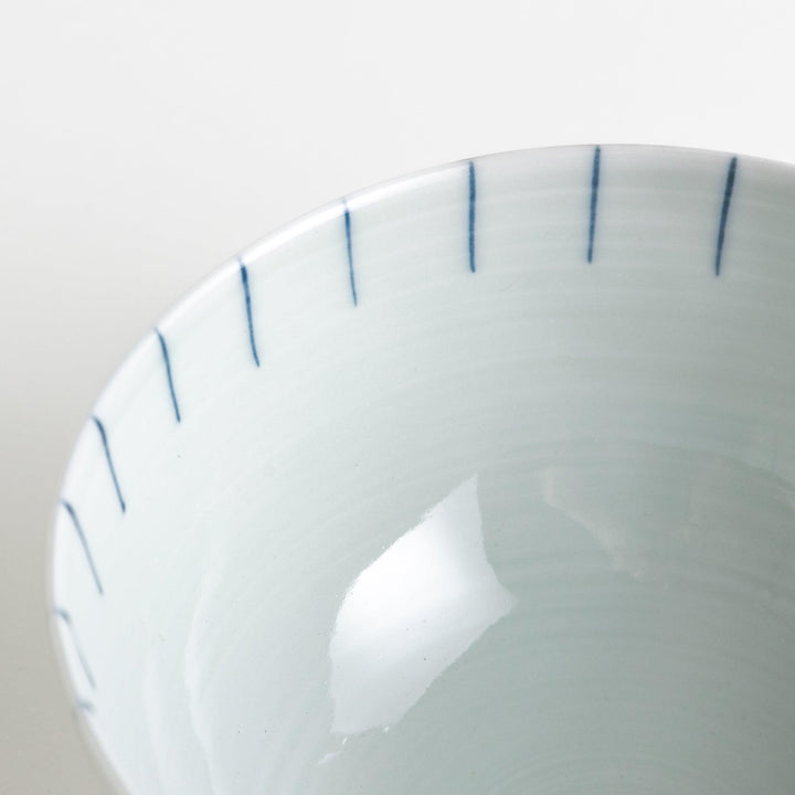 A white ceramic bowl with vertical blue stripes in a simple, clean design.