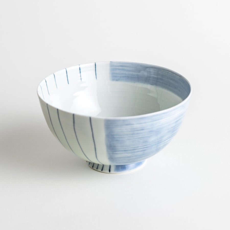 A white ceramic bowl with vertical blue stripes in a simple, clean design.