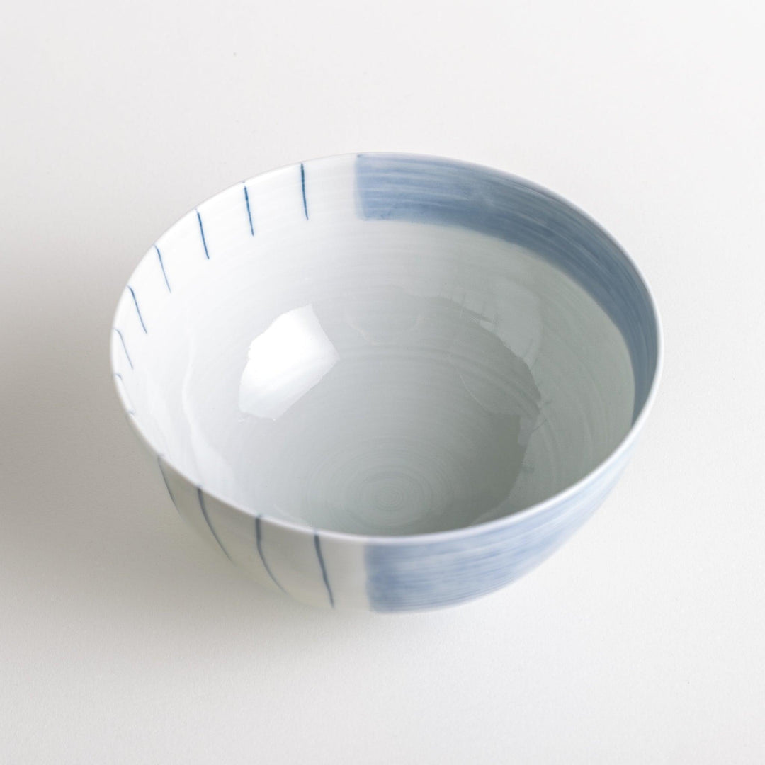 A white ceramic bowl with vertical blue stripes in a simple, clean design.