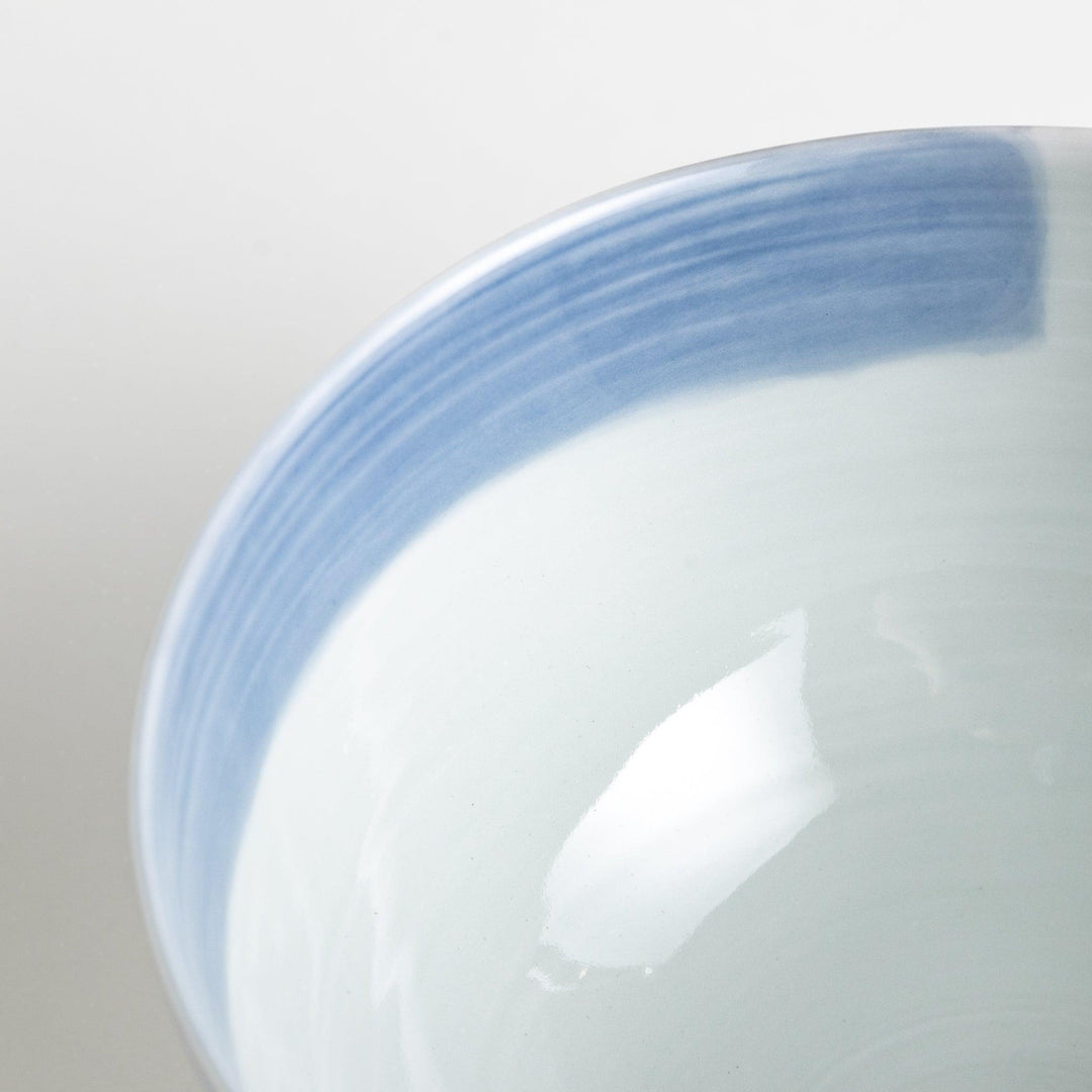 A white ceramic bowl with vertical blue stripes in a simple, clean design.