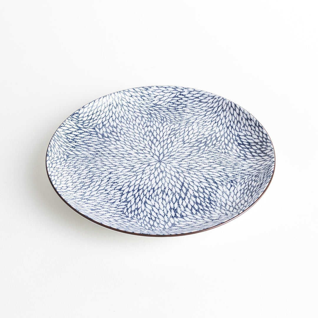 A round dinner plate adorned with a complex blue radial pattern spreading from the center.