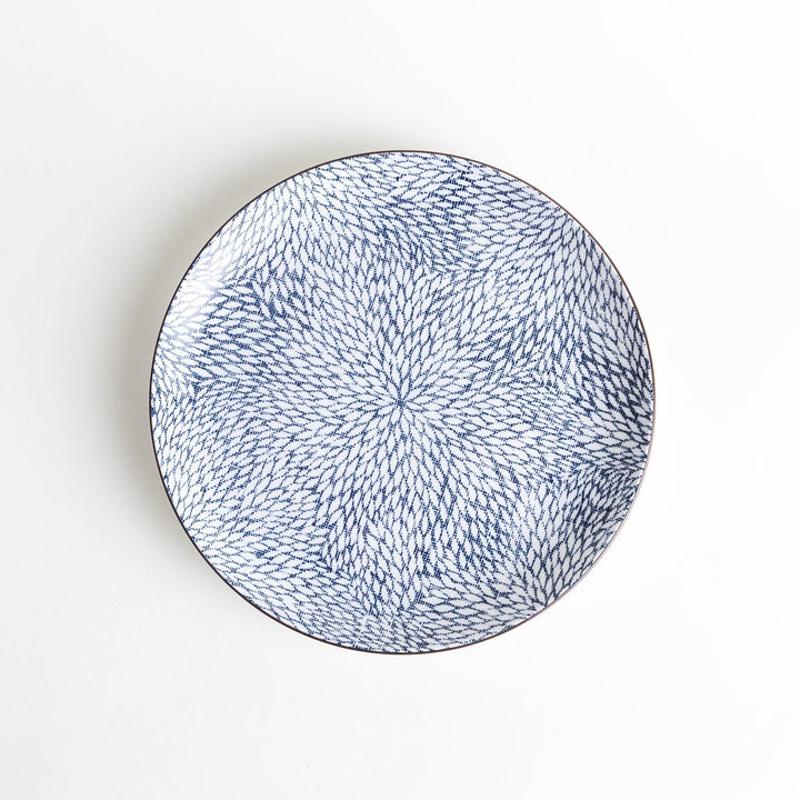 A round dinner plate adorned with a complex blue radial pattern spreading from the center.