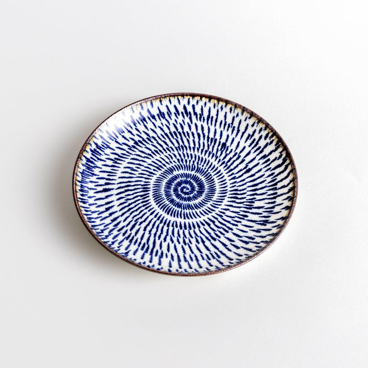 A blue and white salad plate with a concentric spiral pattern/