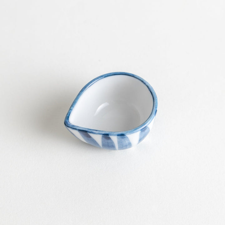 A small condiment bowl with a distinct blue and white vertical stripe pattern.