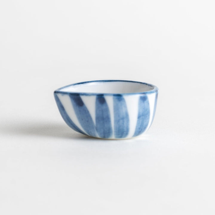 A small condiment bowl with a distinct blue and white vertical stripe pattern.