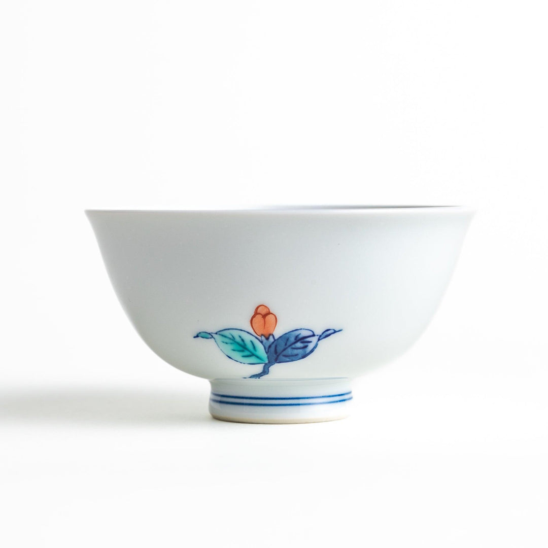 A small, white ceramic rice bowl with a colorful floral design in red, blue, and green.