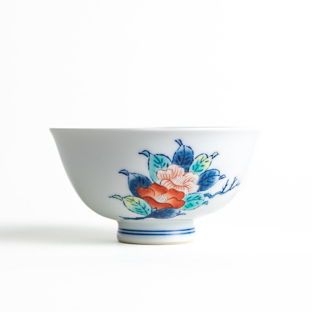 A small, white ceramic rice bowl with a colorful floral design in red, blue, and green.