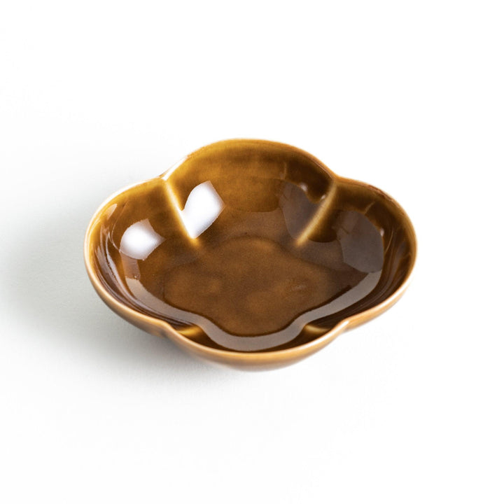 A small, brown ceramic dish shaped like a quince.