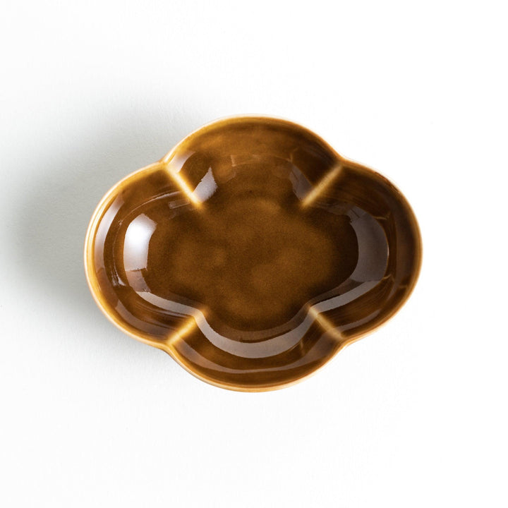 A small, brown ceramic dish shaped like a quince.