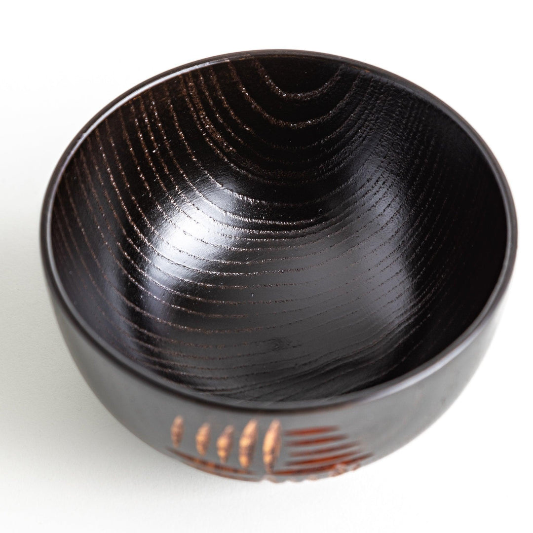 A traditional lacquered wooden bowl featuring a hand-carved pattern of lines and geometric shapes. Available in black or red.