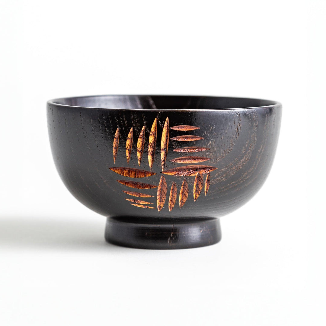 A traditional lacquered wooden bowl featuring a hand-carved pattern of lines and geometric shapes. Available in black or red.