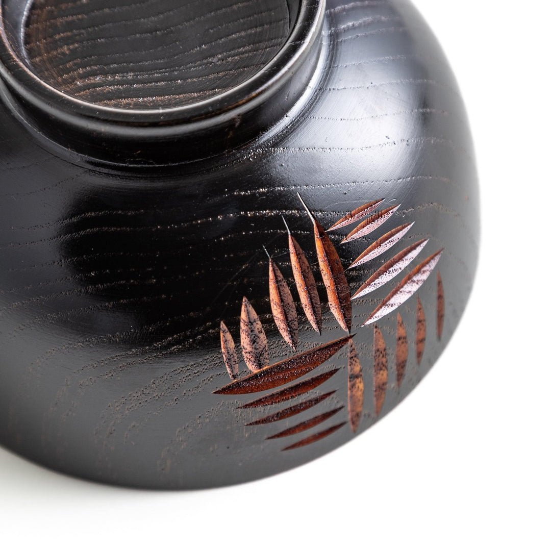 A traditional lacquered wooden bowl featuring a hand-carved pattern of lines and geometric shapes. Available in black or red.