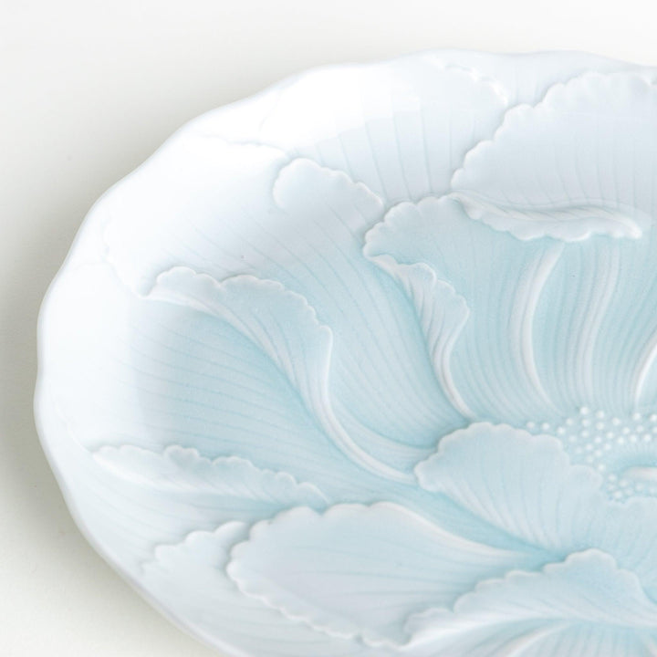 A large oval serving plate with a subtle raised floral design in celadon, featuring a delicate pattern of petals.