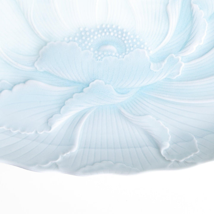 A large oval serving plate with a subtle raised floral design in celadon, featuring a delicate pattern of petals.