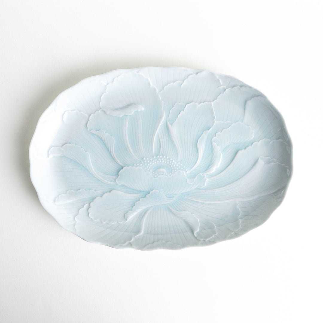 A large oval serving plate with a subtle raised floral design in celadon, featuring a delicate pattern of petals.