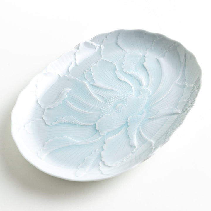 A large oval serving plate with a subtle raised floral design in celadon, featuring a delicate pattern of petals.