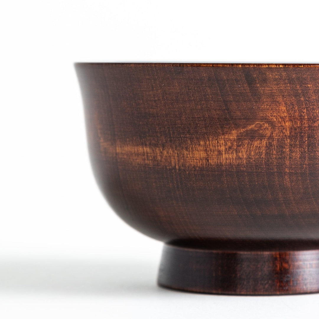 A wooden soup bowl featuring a dark brown grain finish with a sleek black interior.