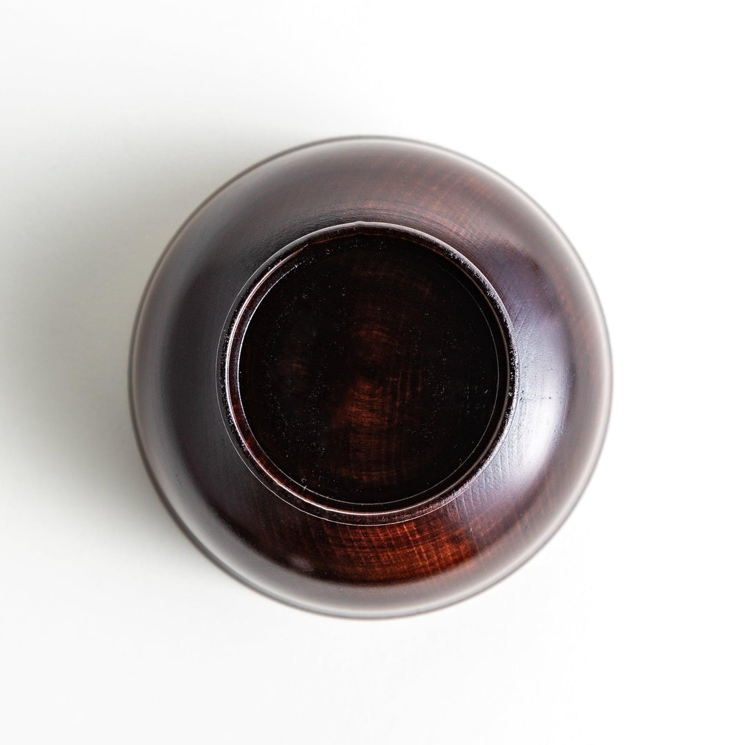 A wooden soup bowl featuring a dark brown grain finish with a sleek black interior.