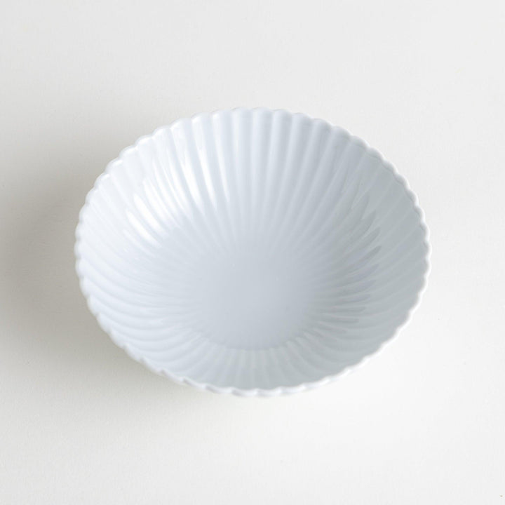 A white ceramic bowl with a delicate scalloped pattern radiating from the center.