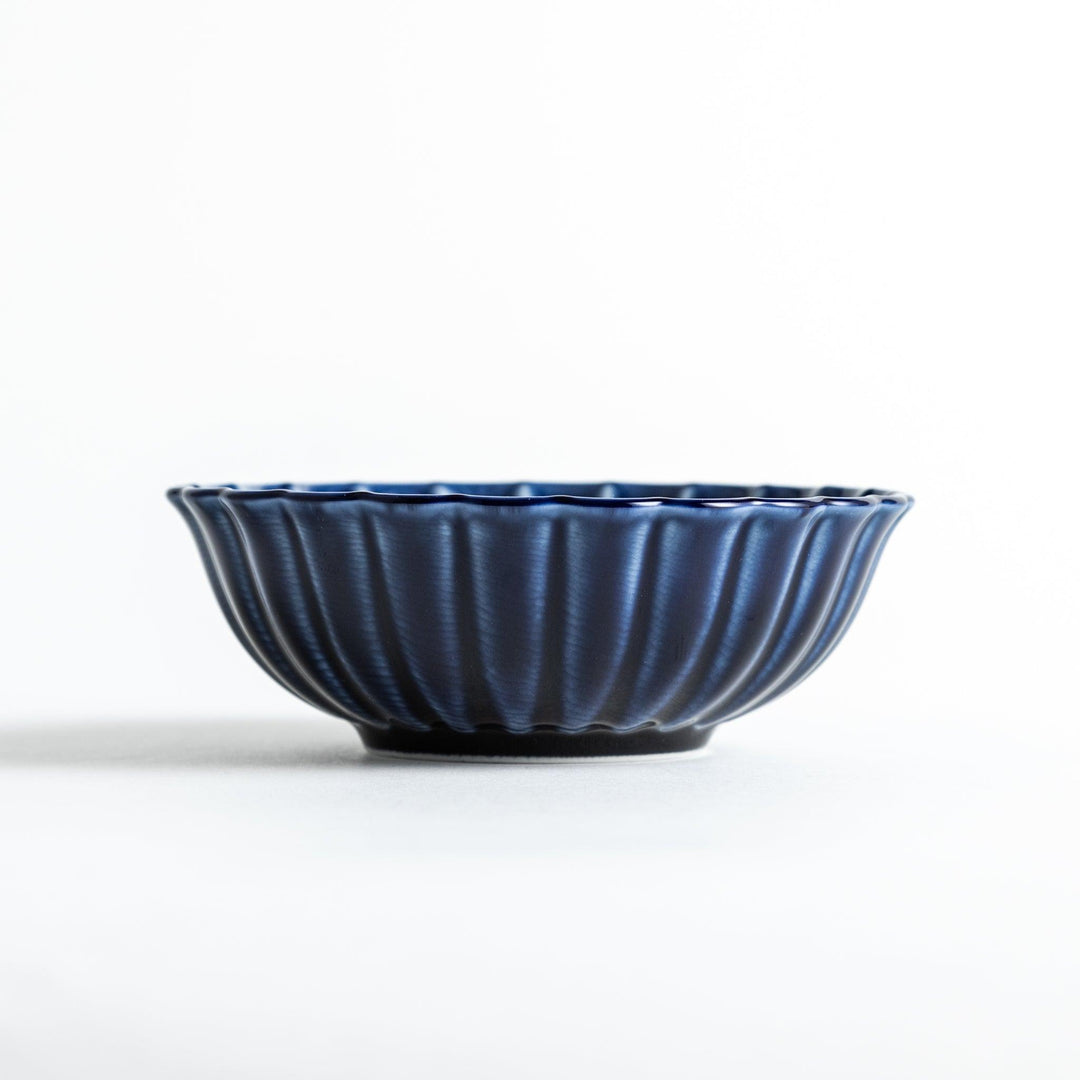 A blue dessert bowl featuring a ribbed pattern from the center outward.