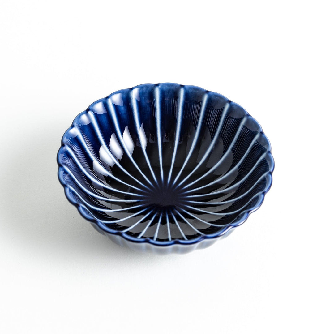 A blue dessert bowl featuring a ribbed pattern from the center outward.