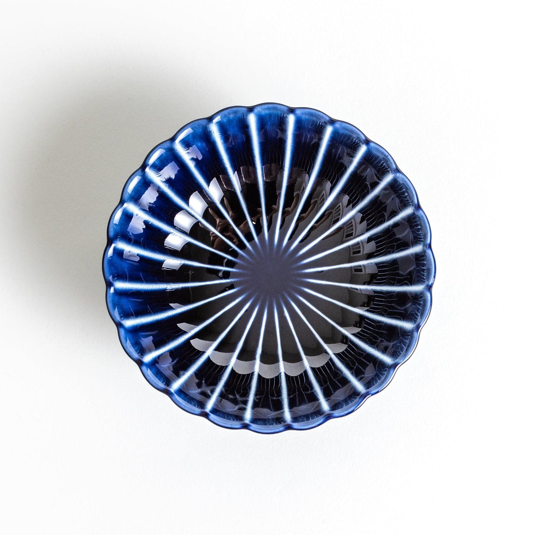 A blue dessert bowl featuring a ribbed pattern from the center outward.