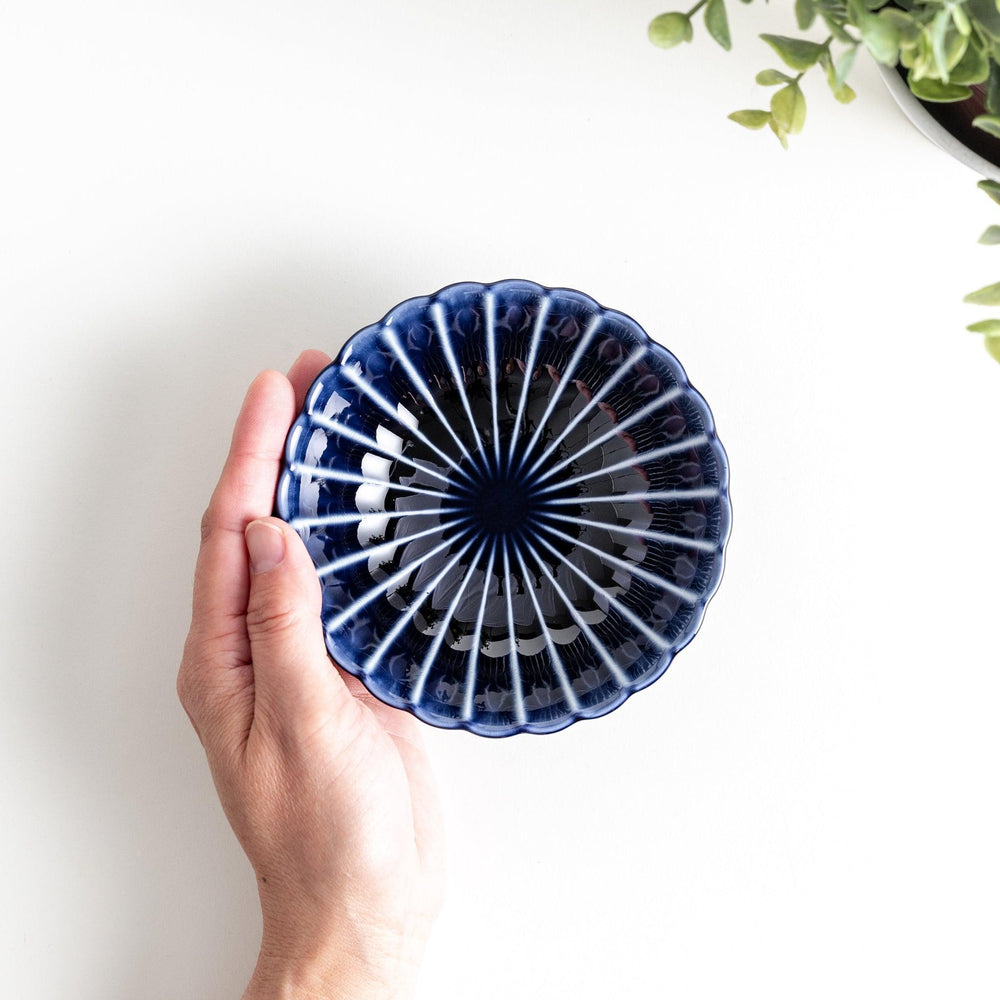 A blue dessert bowl featuring a ribbed pattern from the center outward.