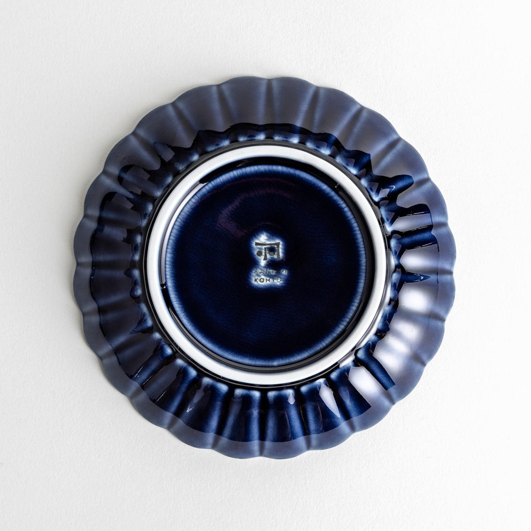 A small, round, blue dish with a ribbed design radiating from the center.