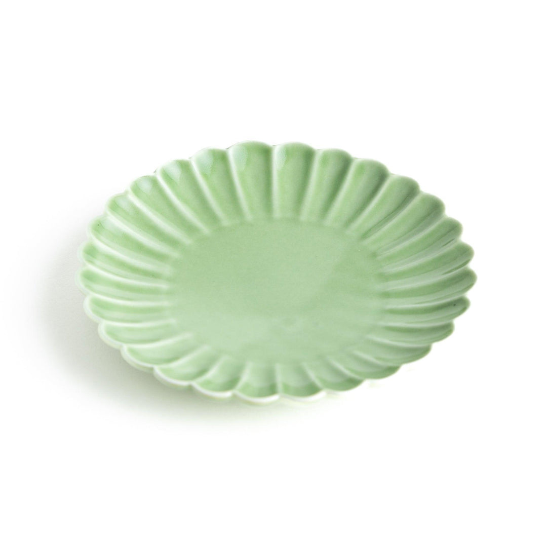 Small sauce dish in various colors (white, green, yellow) with scalloped edges.