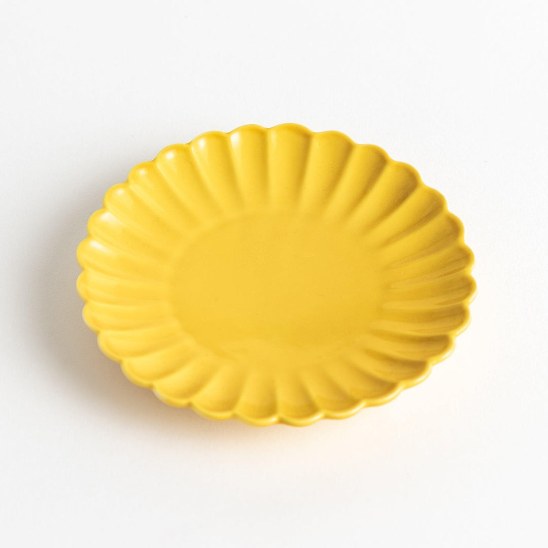 Small sauce dish in various colors (white, green, yellow) with scalloped edges.