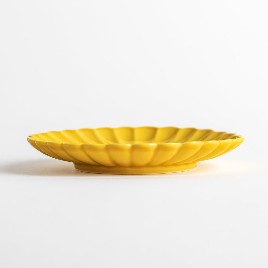 Small sauce dish in various colors (white, green, yellow) with scalloped edges.