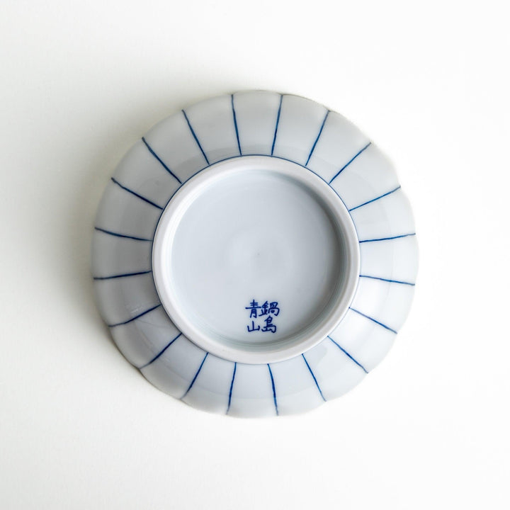 A small green cereal bowl with a scalloped edge and a blue and white wave pattern in the center.