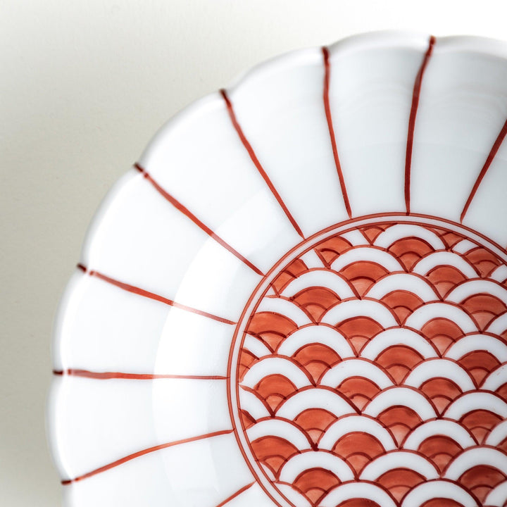 A small green cereal bowl with a scalloped edge and a blue and white wave pattern in the center.