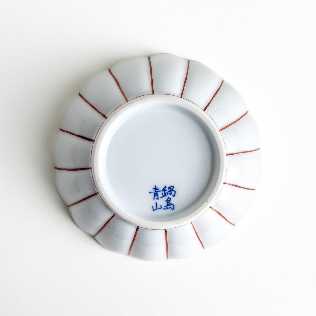 A small green dessert bowl with a scalloped edge and a blue and white wave pattern in the center.