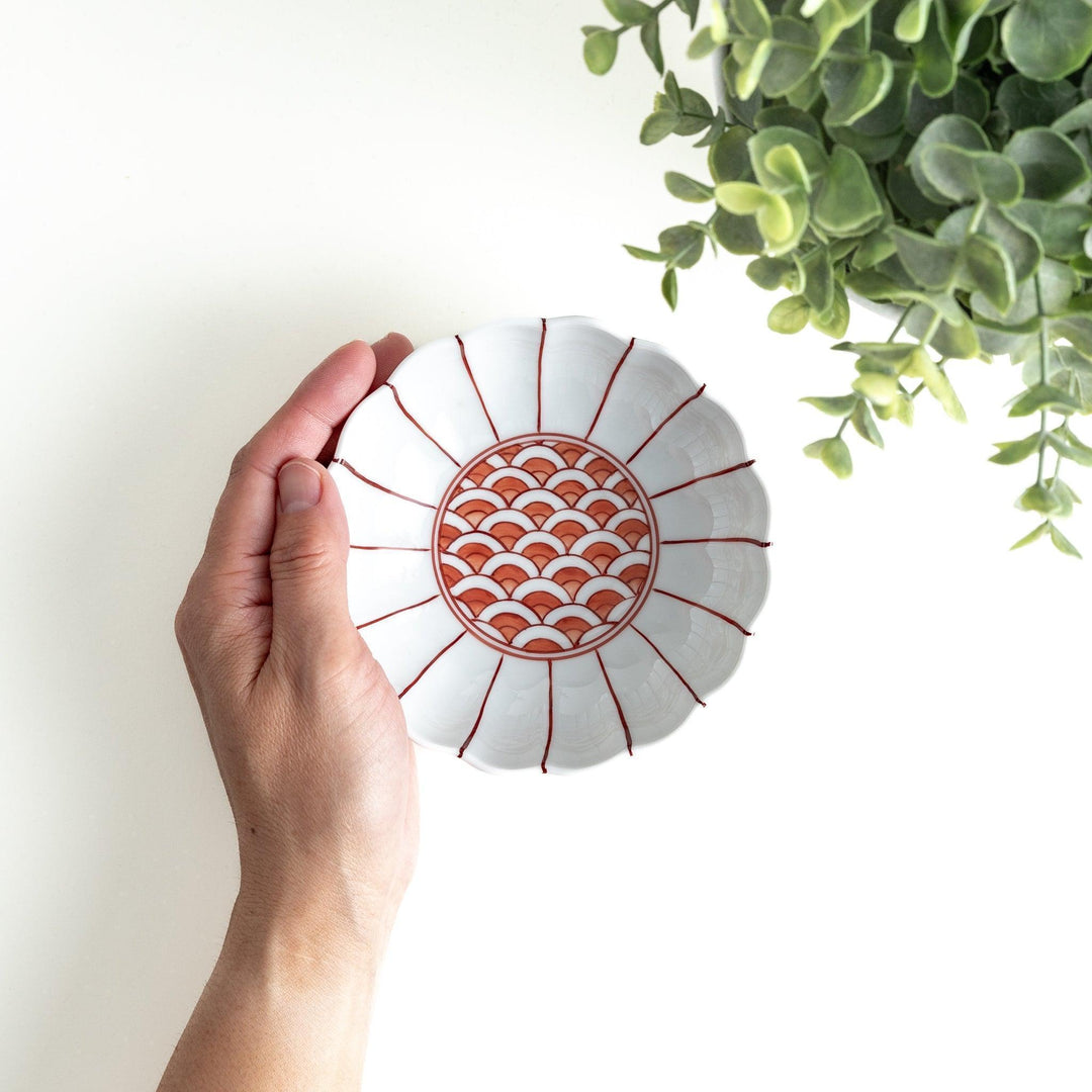 A small green dessert bowl with a scalloped edge and a blue and white wave pattern in the center.