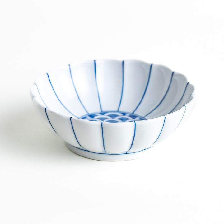 A small green dessert bowl with a scalloped edge and a blue and white wave pattern in the center.