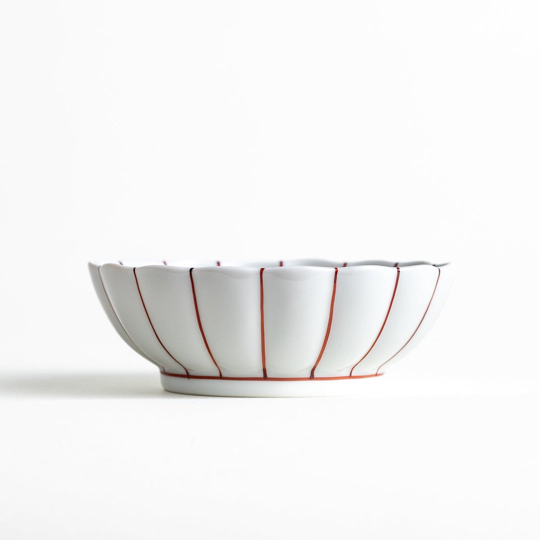 A small green dessert bowl with a scalloped edge and a blue and white wave pattern in the center.