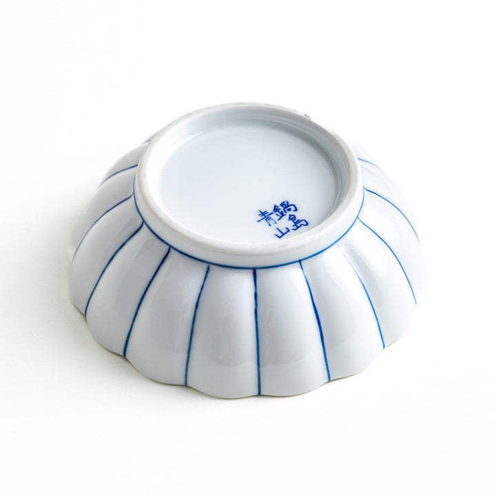 A small green dessert bowl with a scalloped edge and a blue and white wave pattern in the center.