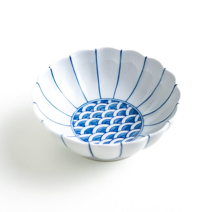 A small green dessert bowl with a scalloped edge and a blue and white wave pattern in the center.