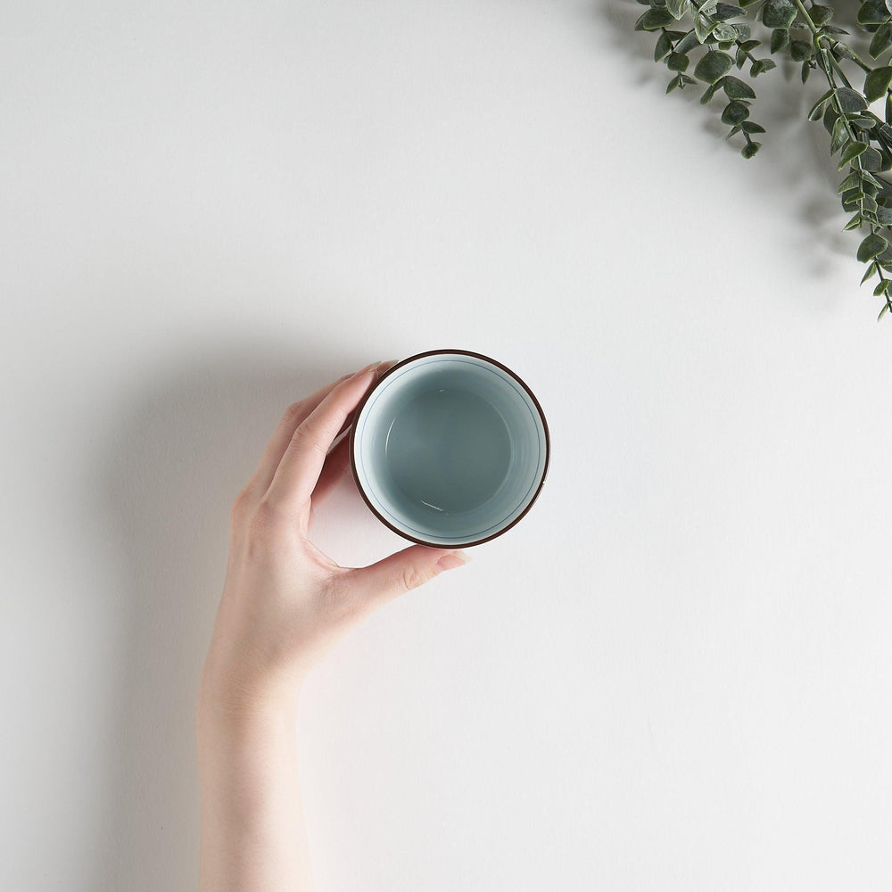 A small cylindrical cup featuring a detailed blue spiral pattern on a white base.