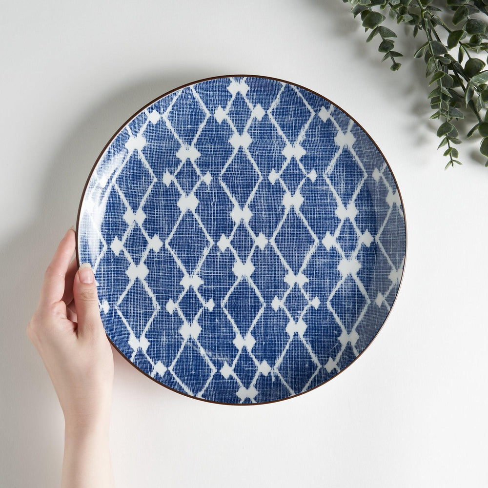 A round dinner plate displaying a blue and white lattice design, similar to traditional Japanese patterns.