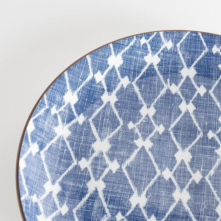 A round serving plate featuring a bold blue and white geometric lattice pattern, perfect for a contemporary table setting.