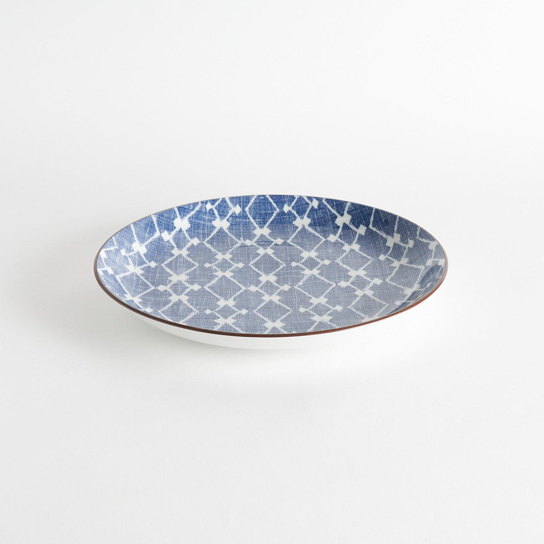 A round serving plate featuring a bold blue and white geometric lattice pattern, perfect for a contemporary table setting.