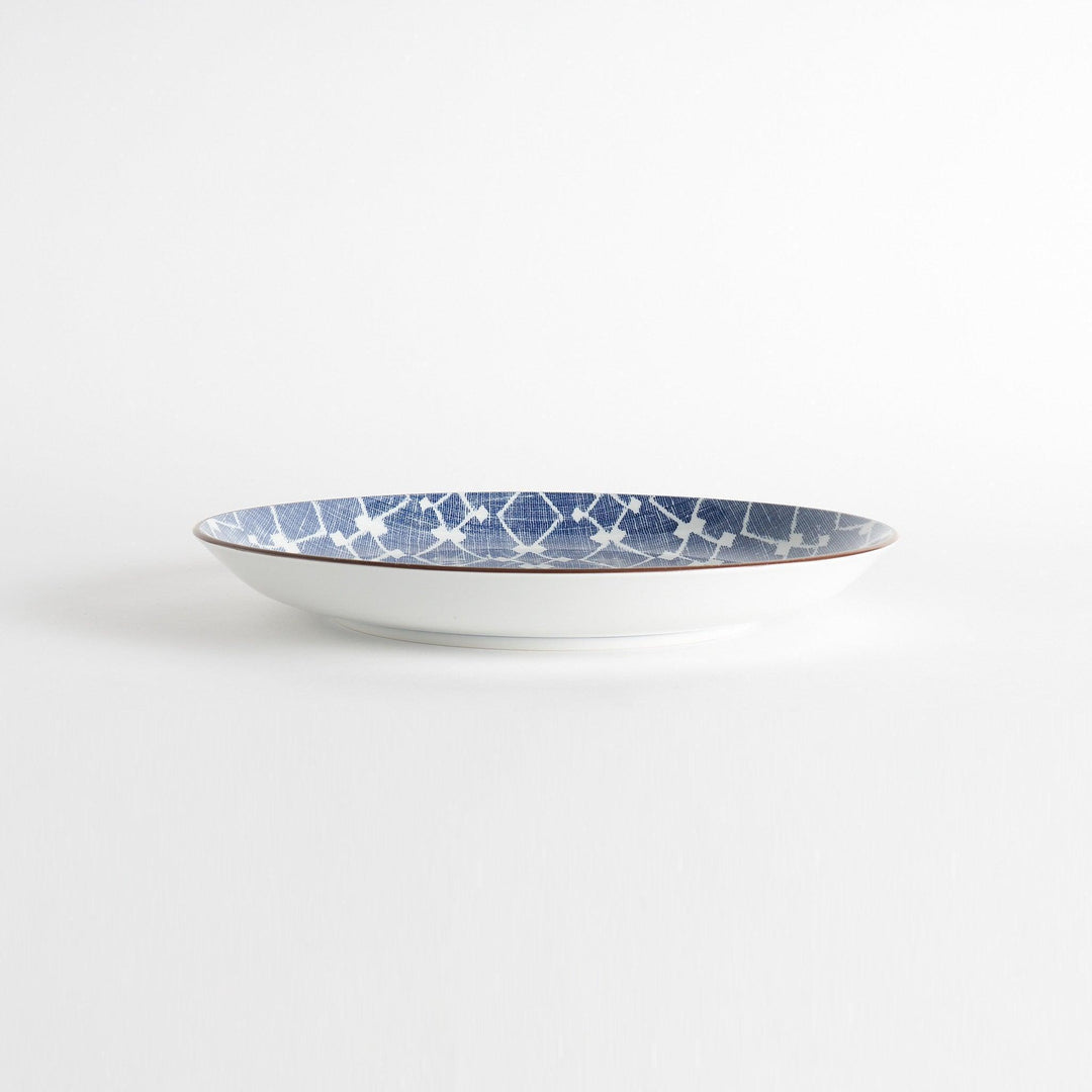 A round serving plate featuring a bold blue and white geometric lattice pattern, perfect for a contemporary table setting.