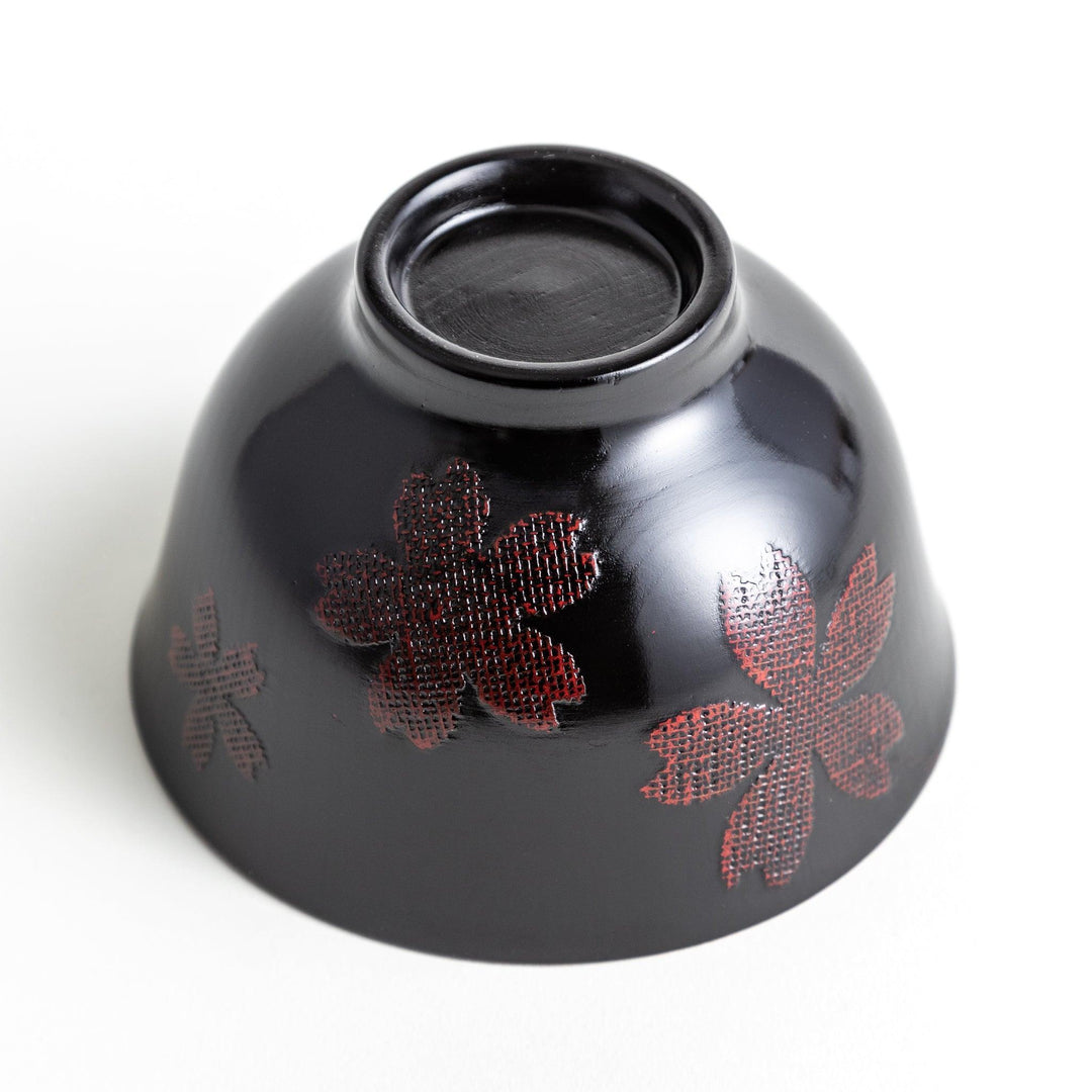 A lacquered bowl featuring a textured black floral design and a smooth, polished finish. Available in black or red.